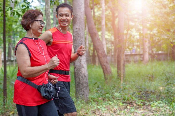 Boldog vezető ázsiai nő, ember, vagy kocogás a parkban, idősgondozás gyakorlat sport tevékenység fogalmát személyi edző - Fotó, kép