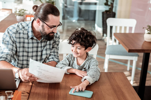 Caring bearded father asking his son about dish for dinner - Photo, image