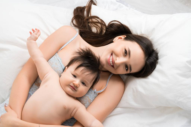 Onnellinen äiti sängyssä vauva poika korkea kulma ammuttu
 - Valokuva, kuva