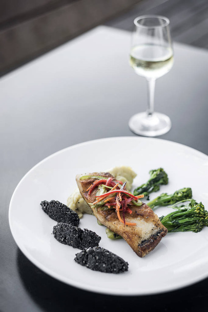 λυθρίνι φιλέτο ψαριού με λαχανικά και μαύρο ρύζι με μαύρο σουσάμι σπόρων Ασιατική Σύγχρονη Φιούζιον πιάτο στη Μελβούρνη Αυστραλία εστιατόριο - Φωτογραφία, εικόνα