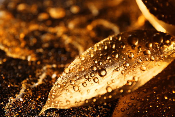 Golden leaves with drops on textured background, closeup - Φωτογραφία, εικόνα