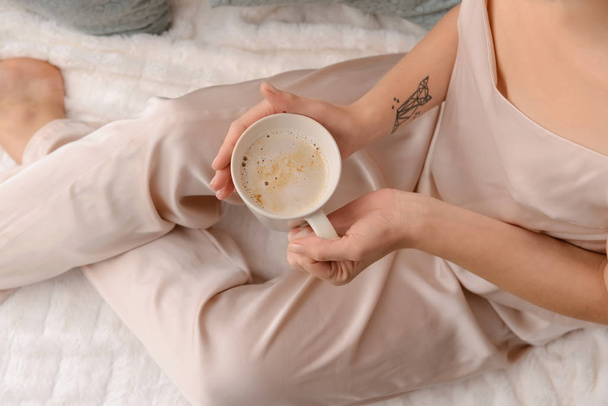 Mujer bebiendo café aromático en la cama, primer plano
 - Foto, imagen
