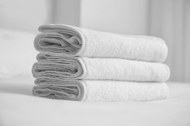 Serviettes pliées blanches douces sur lit intérieur
 - Photo, image