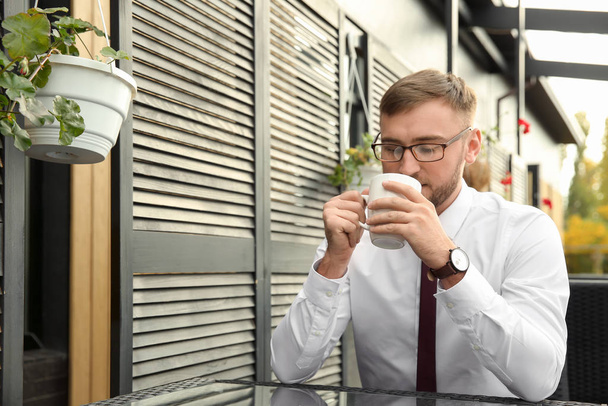 Businessman drinking coffee in cafe - Foto, imagen