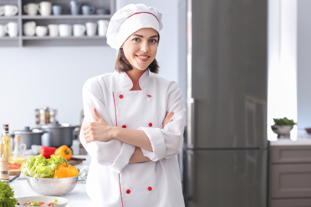 Young female chef in kitchen - 写真・画像