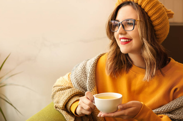 Schöne junge Frau trinkt zu Hause heißen Tee - Foto, Bild