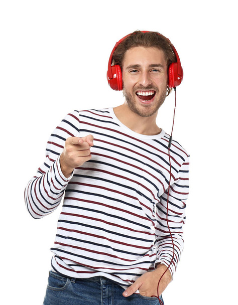 Young man listening to music on white background - Foto, afbeelding