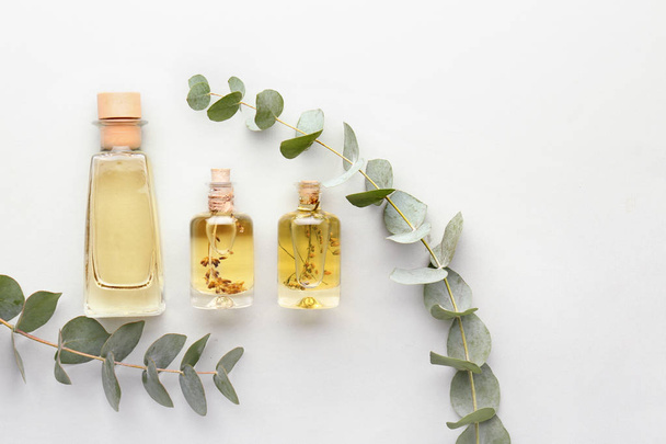 Бутылки эфирного масла эвкалипта на светлом фоне
 - Фото, изображение