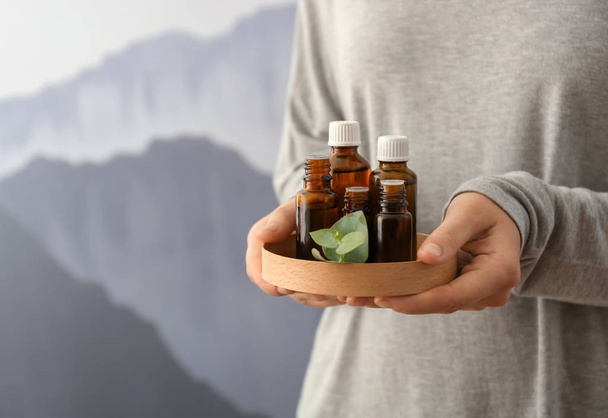 Woman with bottles of eucalyptus essential oil, closeup - Photo, Image