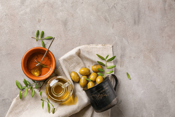 Composition with olive oil on grey background - Fotoğraf, Görsel
