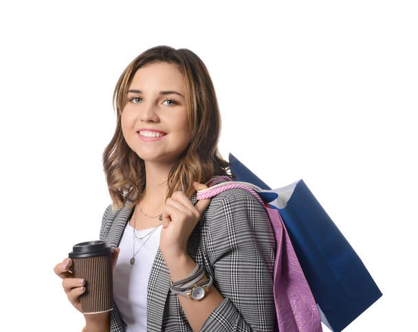 Hermosa joven con bolsas de compras y café sobre fondo blanco
 - Foto, imagen
