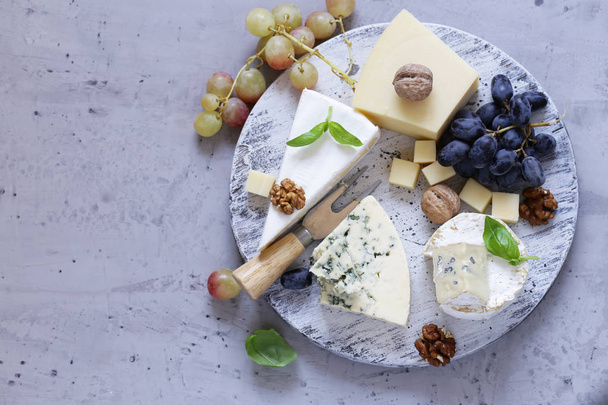 tabla de quesos queso blando, frutos secos y uvas
 - Foto, Imagen