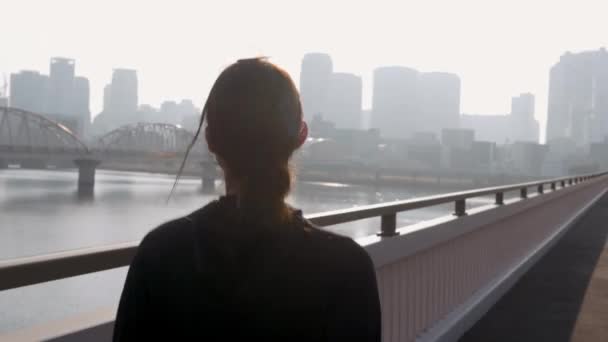 Healthy Japanese girl running across a bridge. - Filmati, video
