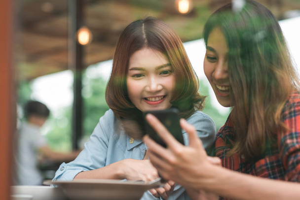 Boldog szép ázsiai meg nők blogger használ fénykép smartphone és így élelmiszer vlog videóinak neki előfizetők és a csatorna kávézóban. - Fotó, kép