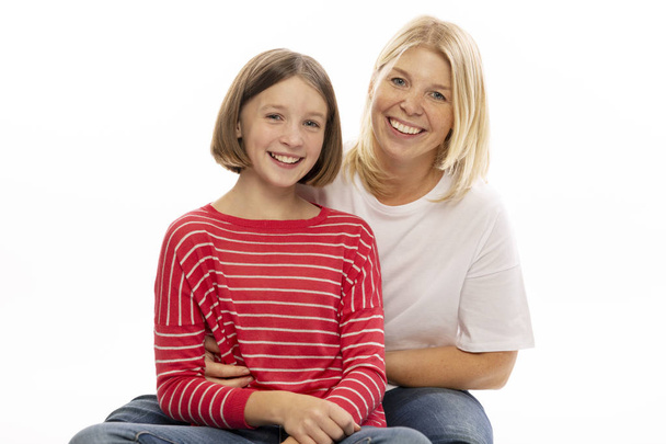 Mom with her teenage daughter hugging and laughing, white background - Foto, Imagem