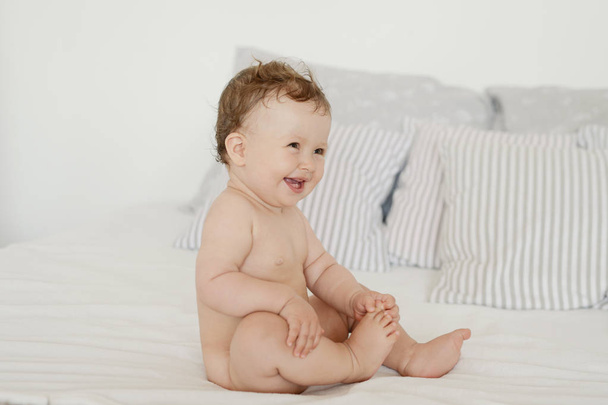 baby on a bright bed - Foto, afbeelding