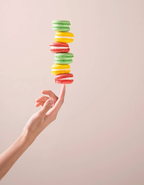 macaroon cake in motion over hand - Photo, image