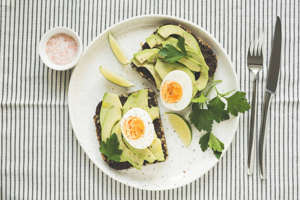 Avocado and egg on rye bread, top view - Valokuva, kuva