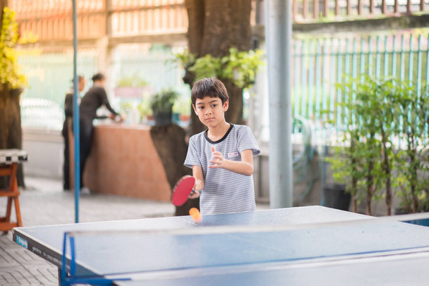 Kid playing table tennis outdoor with family - Foto, Imagem