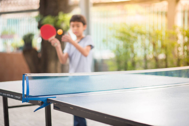 Dziecko grając w tenisa stołowego odkryty z rodziną - Zdjęcie, obraz