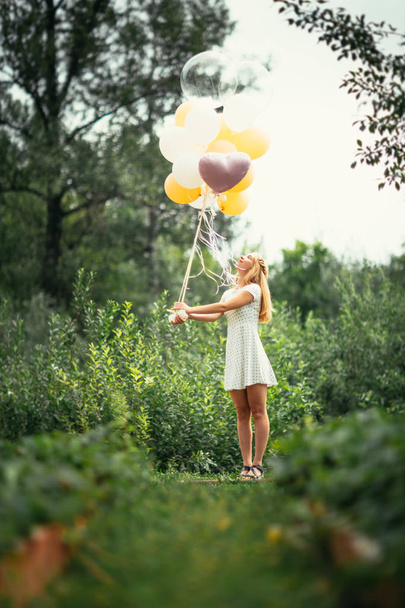 young girl with balloons on nature background. - Foto, immagini