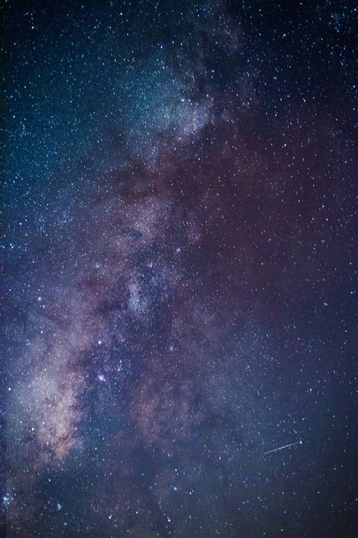 Via Láctea. Fantástica paisagem noturna com forma leitosa roxa, céu cheio de estrelas, estrelas brilhantes. Bela cena com universo. Espaço fundo com céu estrelado
 - Foto, Imagem