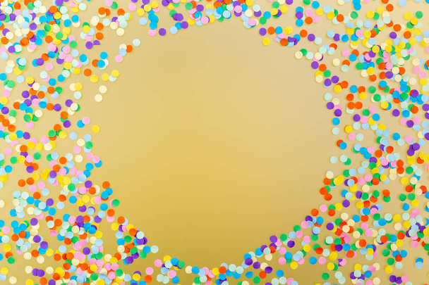 Marco redondo de confeti colorido sobre fondo amarillo
.  - Foto, imagen