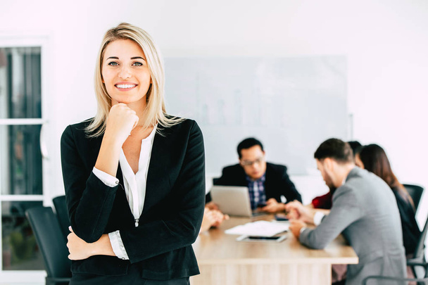 Geschäftsfrau Managerin steht lächelnd mit Business-Team zusammen arbeiten im Büro Hintergrund. - Foto, Bild