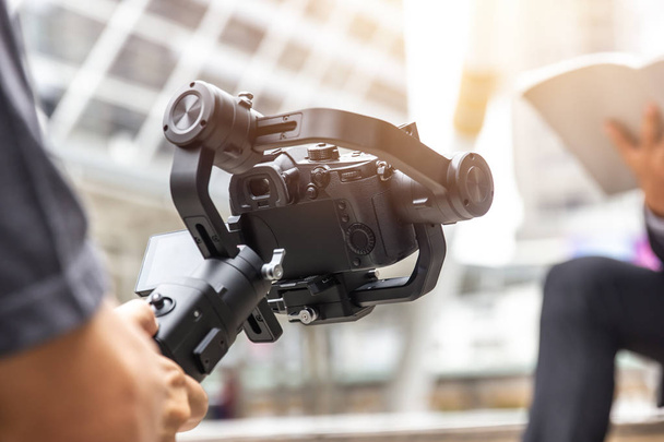 gimbal motorizado, videógrafo usando câmera dslr anti shake ferramenta para estabilizador gravar cena de vídeo
. - Foto, Imagem
