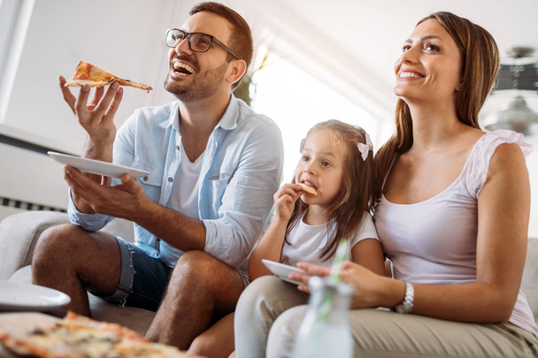 Portrait of happy family sharing pizza together at home - Фото, зображення
