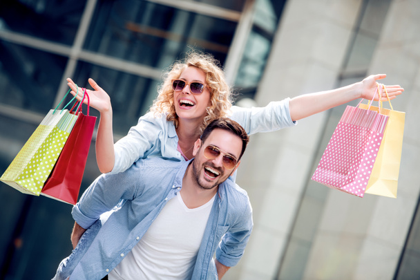 Giovane coppia felice con shopping bag in città, divertirsi insieme
. - Foto, immagini
