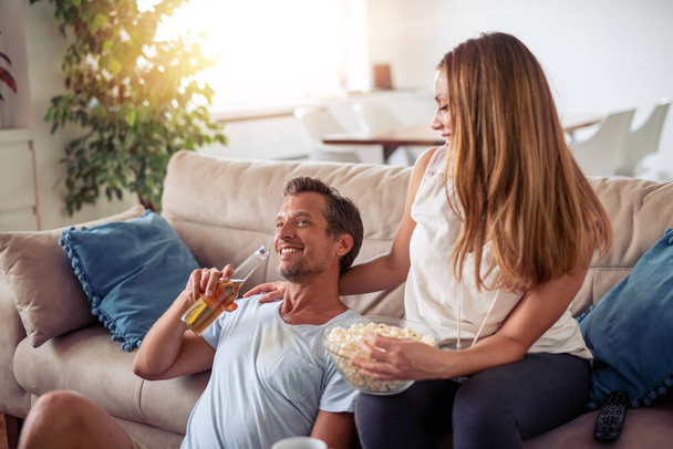 Happy young couple watching movie at home. - Foto, imagen