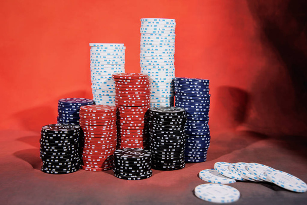 Abstraktní fotka z kasina. Poker hra na červeném pozadí. Téma hazardních her. - Fotografie, Obrázek
