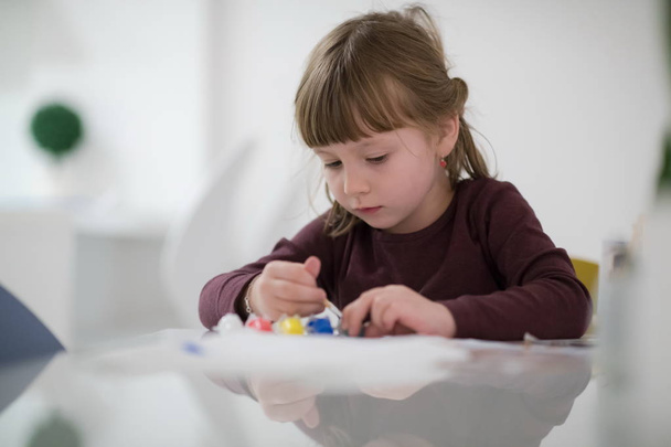 happy little girl painting on canvas image at home - Valokuva, kuva