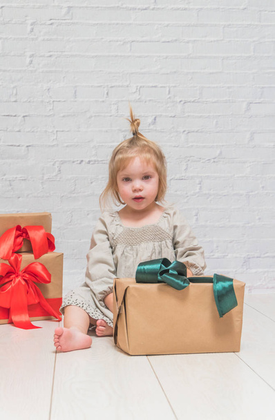 the baby, girl birthday gift, holiday, Christmas, white brick wall background - Φωτογραφία, εικόνα