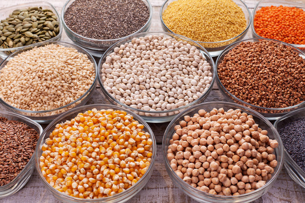 Various grains and seeds in glass bowls, diversified nutrition concept - closeup - Photo, Image