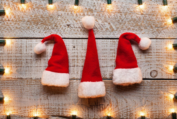 Christmas hats and decorative lights frame background - holidays season symbols, getting in the mood - Photo, Image
