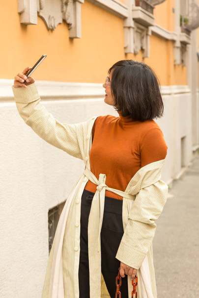 Beautiful young Indian woman taking a selfie in an urban context. Street fashion and style. - Valokuva, kuva