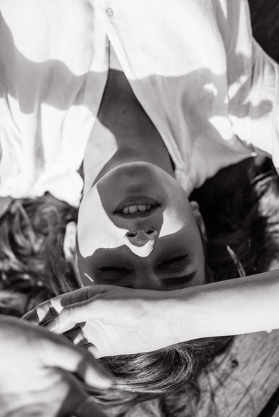 Yleisnäkymä nainen valkoinen paita makaa puinen laituri nosti kädet
 - Valokuva, kuva