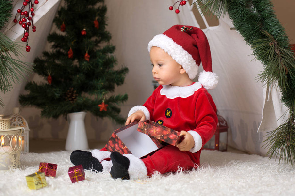 カンタ クロース コスチューム、テントの前に自宅で再生がクリスマスの装飾に身を包んだ愛らしい小さな幼児男の子 - 写真・画像