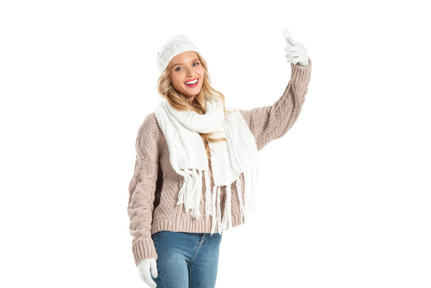 jeune femme souriante en pull d'hiver prenant selfie sur smartphone isolé sur blanc
 - Photo, image