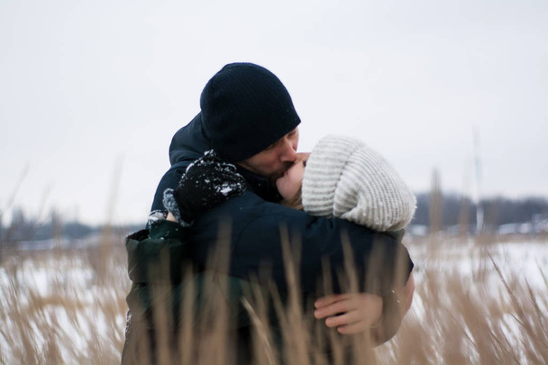 Genç Romantik Çift açık havada Noel öncesi kışın eğleniyor. Yeni yıl arifesi içinde birlikte vakit zevk. İki sevgili sarılma ve öpüşme Saint Valentine's Day. - Fotoğraf, Görsel