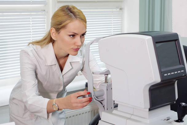 oftalmólogo mujer con dispositivo oftalmológico en el gabinete
. - Foto, Imagen