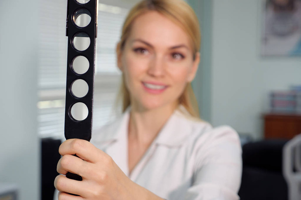 ophthalmologic device and beautiful smiling eye doctor at the a blurred background. - Photo, Image