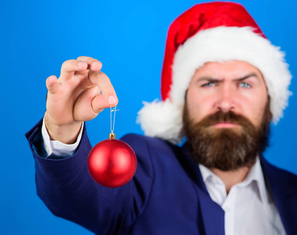 Man bearded hipster wear formal suit and santa hat. Special christmas offer. Santa hold christmas ball decoration. Business and christmas concept. Businessman offer you join christmas preparation - 写真・画像