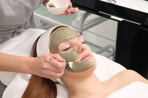 gezichtsbehandeling van jonge vrouw in een salon cosmetologie - Foto, afbeelding