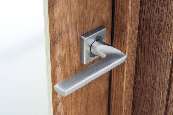 Close-up of modern steel door handle with lock. Dark oak and frosted glas - Photo, image