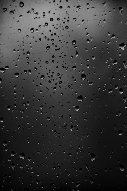 暗いガラスの背景に雨滴 - 写真・画像
