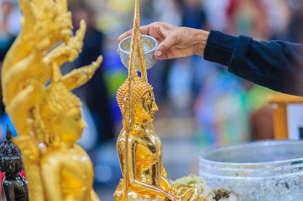 Κλείστε το χέρι του λαού της Ταϊλάνδης, λούζοντας ιεροτελεστία σε εικόνες του Βούδα στο Songkran Φεστιβάλ στις 13 Απριλίου ετήσιο τελετουργικό κάθε χρόνο. Βουδιστική κολύμβησης ένα άγαλμα του Βούδα να αποκτήσουν αξία κατά τη διάρκεια της Ταϊλάνδης νέο έτος.  - Φωτογραφία, εικόνα