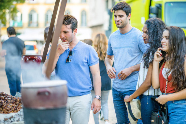 Group of friends want to buy roasted chestnut from street seller, Spain - Foto, Imagem